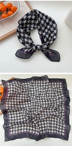 Detail of black and white houndstooth scarf with purple border and sheer edges