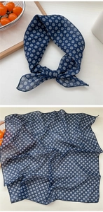 Detail of navy blue floral cotton scarf showing semi-transparent fabric and white flower patterns