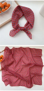 Detail of red floral cotton linen scarf showing delicate patterns and hemmed edges