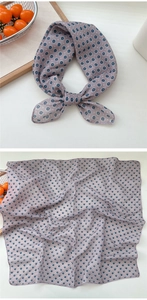 Detail of floral linen neck scarf featuring a small blue flower pattern on gray fabric