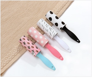 Four portable lint rollers with colorful patterns displayed on a soft knit background