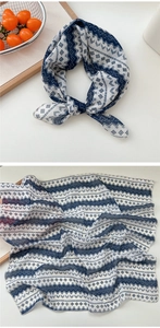 Close-up of lightweight geometric cotton scarf with blue ethnic patterns and wood decor