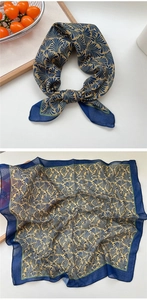 Detailed view of square silk scarf with fan patterns in deep blue and gold tones
