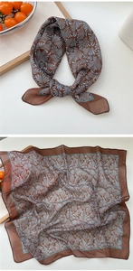Detail of soft linen-cotton square scarf with blue leaf patterns on brown fabric