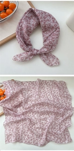 Detail of floral linen-feel neck scarf featuring intricate rolled edges and a botanic print