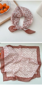 Detail view of a vintage floral square scarf with rust red patterns on cream fabric