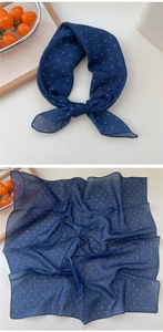 Detail eines dunkelblauen Chiffon-Halstuchs mit Punkten und weicher Textur