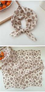Detailansicht eines beigen Polka-Dot-Seidentuchs mit Schleife und feinem Rollsaum