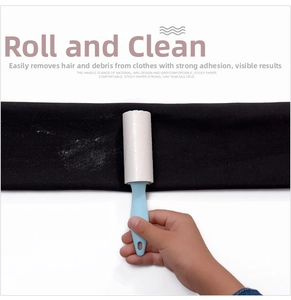 Detail of portable lint roller removing white hair from black fabric with strong adhesion