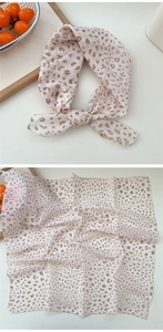 Detailansicht eines Seidenschals mit Leopardenmuster als geknotetes Haarband und flach