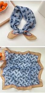 Macro detail of geometric diamond pattern scarf with yellow border and knotted style