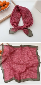 Close-up of vintage geometric pattern silk scarf with elegant red and green contrast edges