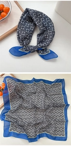 Detail of grey square cotton linen scarf with clover pattern and blue border decor