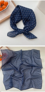 Detail of navy blue cotton linen scarf with orange geometric patterns and draped texture