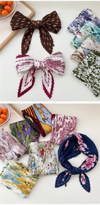 Makroaufnahme von plissierten Seidenschals mit Paisley- und Blumenmustern für das Styling