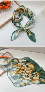 Detailaufnahme des plissierten Seidenschals mit grün-gelbem Retro-Blumenmuster