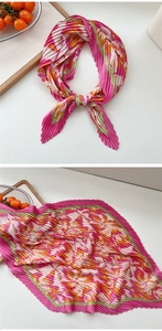 Detailansicht des gefalteten Seidenschals mit buntem Blumenmuster und Stoffstruktur