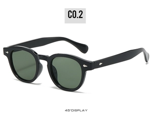 Détail des lunettes de soleil ovales noires avec rivets argentés et verres verts