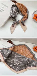 Detail eines mehrfarbigen Seidenschals mit orangefarbenem Muster und Plissee-Stoff