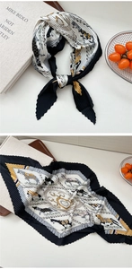 Detail eines plissierten Seidenschals mit Kutschenmotiven und goldenen Akzenten