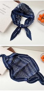 Detailansicht eines marineblauen Faltenhalstuchs mit weißem Punktmuster und feiner Textur