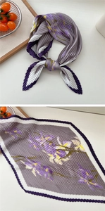 Detail eines floralen plissierten quadratischen Halstuchs mit lila Wellenrandern