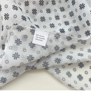 Detailed macro view of the fabric texture and material composition label on the scarf