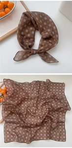 Detail of brown floral cotton linen neck scarf with white flower patterns and soft texture
