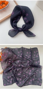 Detail view of navy cotton-linen scarf with pink daisy floral pattern and fine stitching