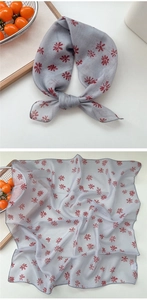 Macro shot of breathable cotton linen scarf featuring delicate red daisy floral prints