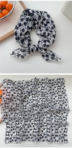 Detailed view of lightweight black floral cotton linen scarf with knotted styling