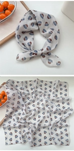 Detail of floral linen neck scarf featuring blue and brown botanical prints on light beige