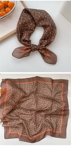 Macro detail of square floral cotton scarf featuring brown base and orange trim accents