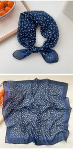 Detail of navy blue cotton linen square scarf featuring white floral prints and striped border