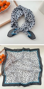 Detail of cotton linen scarf featuring black rose floral prints and blue striped edges