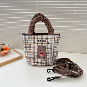 Détail du sac en toile à carreaux avec broderie d'ours et poignée à volants brune