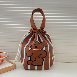 Detail of a brown knitted drawstring handbag with a cute cartoon bear and blue stripes
