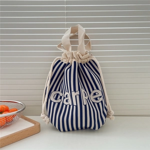 Detail of blue and white striped knit bucket bag with carpe text and drawstring close