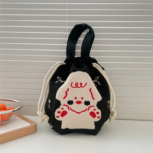 Detail of knitted drawstring bucket bag with cartoon dog motif and soft texture