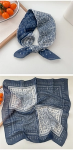 Detail of blue and white paisley square scarf showing print pattern and fabric texture