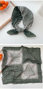 Detail of soft breathable paisley cotton linen scarf with vintage green patterns