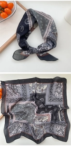 Detail of soft paisley and floral print square scarf in black and grey breathable fabric