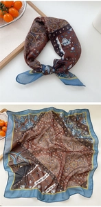 Detail of vintage paisley square scarf with blue floral pattern and smooth texture