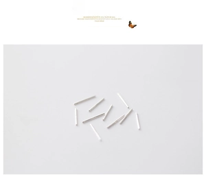 Close-up of polished sterling silver ear studs and piercing pins on white background