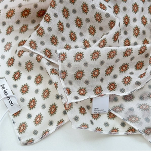 Detail view of cotton linen scarf texture with floral prints and quality fabric label
