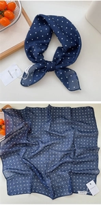 Detail of navy blue polka dot cotton linen scarf with soft texture and rolled edges
