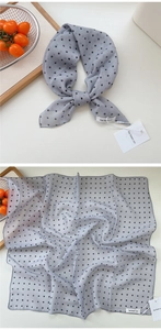 Detailed close-up of grey polka dot cotton linen square scarf with premium hem and brand tag