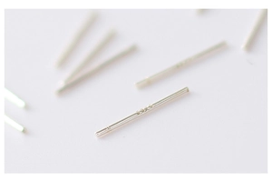 Macro shot of 925 silver ear sticks showing fine texture and polished metallic finish