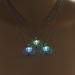 Luminous pumpkin carriage pendants glowing in blue and green in dark environment