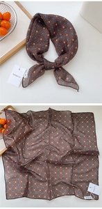 Detailed macro view of dark brown cotton-linen floral scarf with premium hem and brand tag